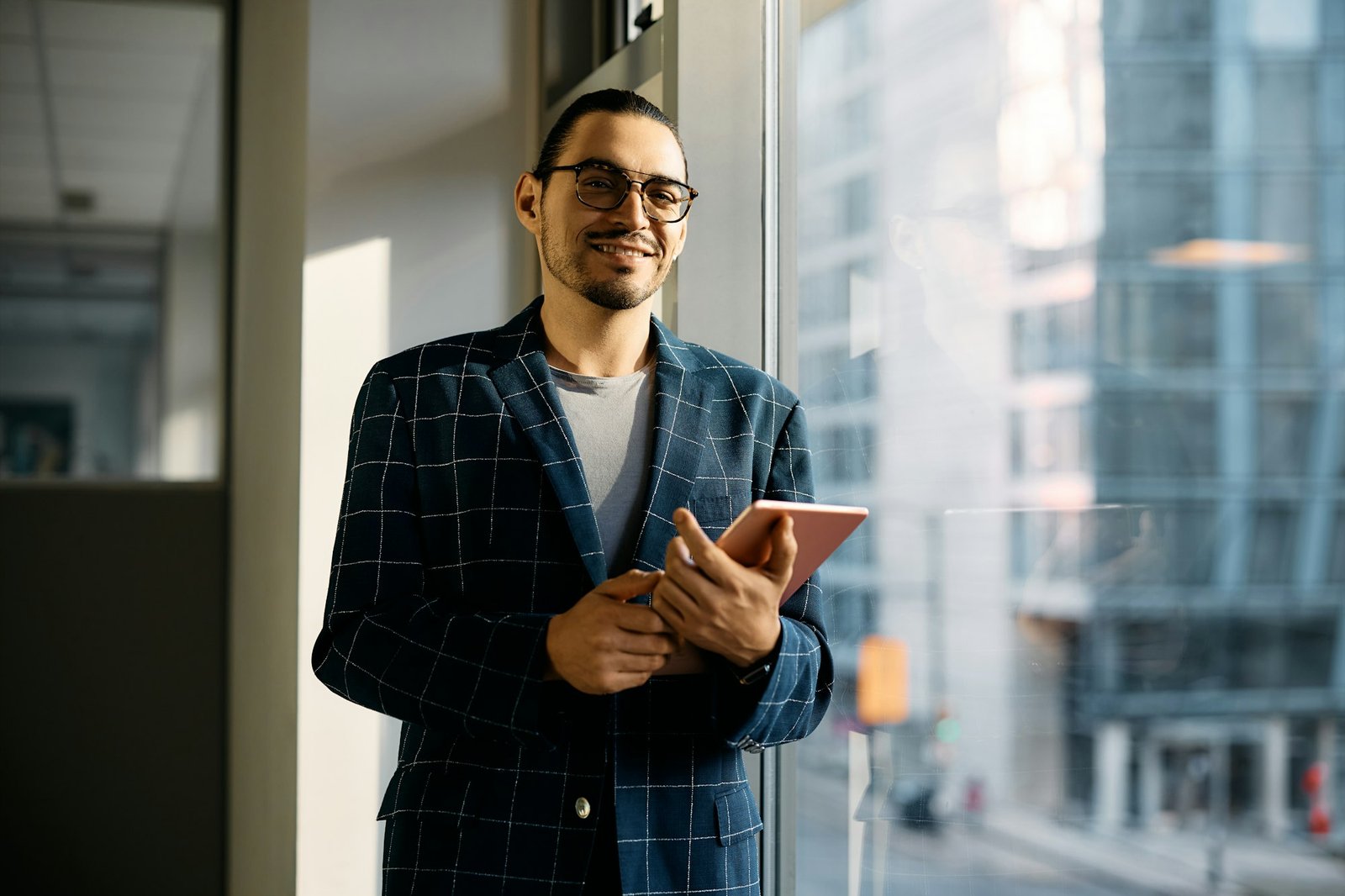 Portrait of Latin American businessman with touchpad in the office looking at camera.